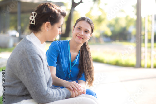 Wallpaper Mural Young caucasian nurse concerned and comforting with sad patient in outdoor park, doctor woman support and counseling with patient, caregiver and service with senior, medical and consoling. Torontodigital.ca