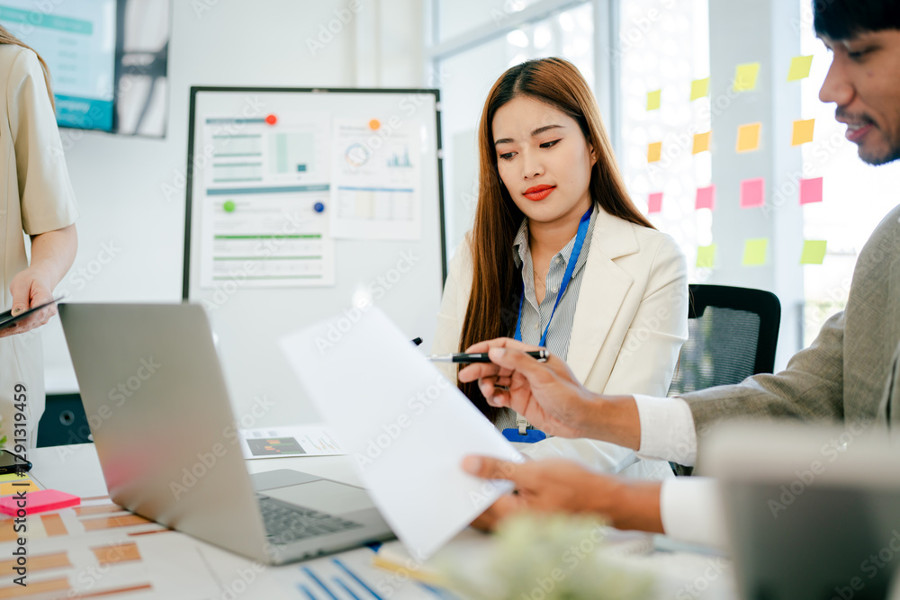 Woman is sitting at a desk with a laptop and a piece of paper Woman is sitting at a desk with a laptop and a piece of paper