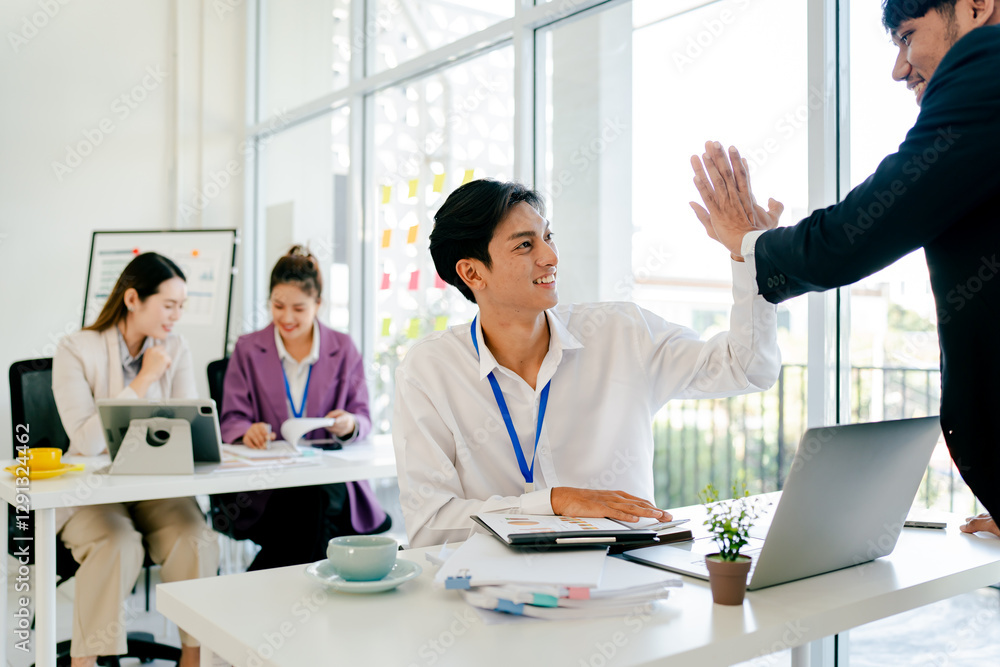Man and a woman are high fiving in a business setting Man and a woman are high fiving in a business setting