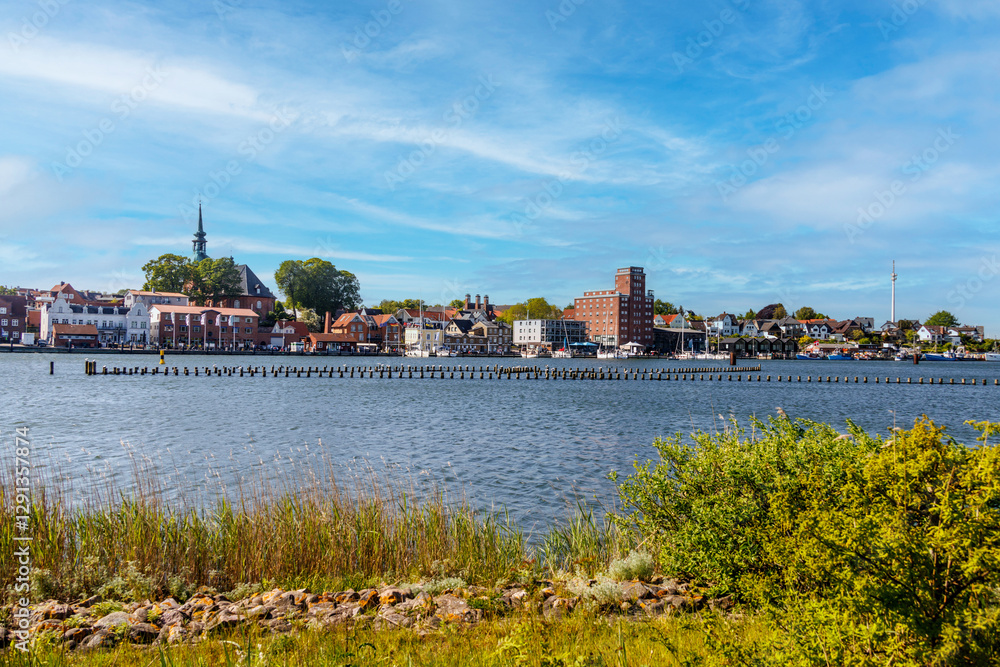 Fototapeta premium Kappeln skyline reflecting on river schlei in summer