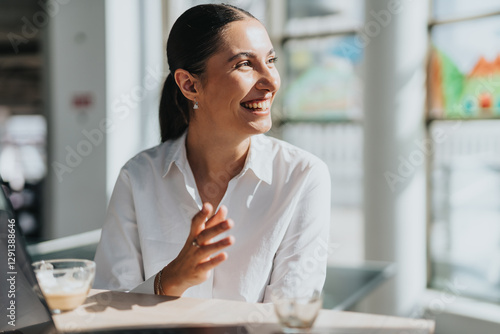 Картината върху платно A smiling businesswoman takes a coffee break in a bright, modern office kitchen