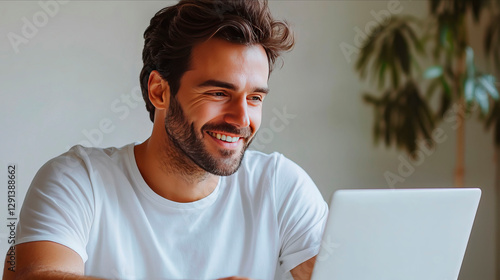 young smiling man looking at the  laptop screen