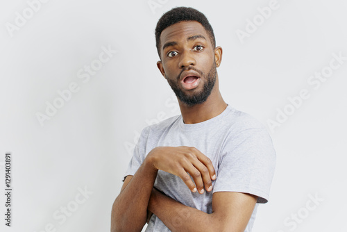 Shocked african american man with crossed arms expressing astonishment and curiosity in casual urban setting photo