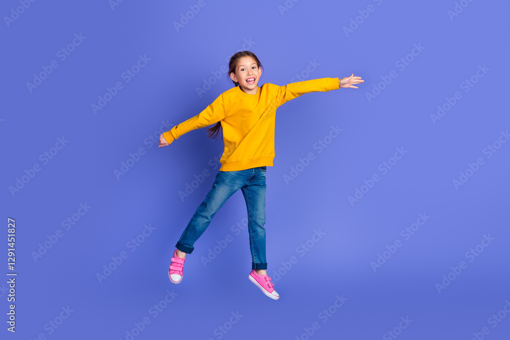Cheerful young girl jumping in vibrant casual attire on purple background embodying youthful energy and joy Cheerful young girl jumping in vibrant casual attire on purple background embodying youthful energy and joy