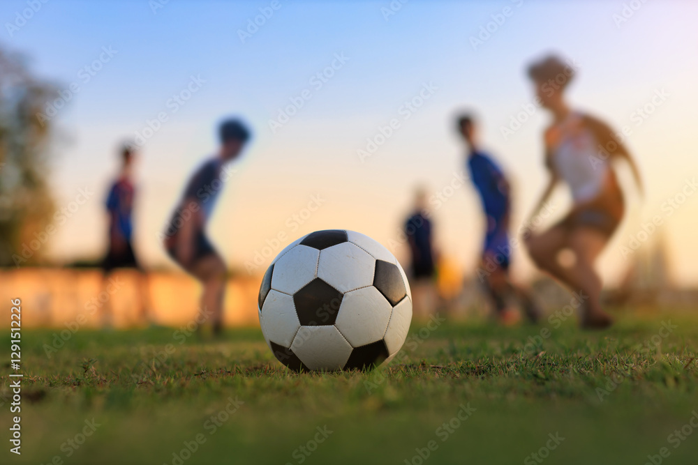 Action sport outdoors of kids having fun playing soccer football for exercise in community rural area under the twilight sunset sky. Action sport outdoors of kids having fun playing soccer football for exercise in community rural area under the twilight sunset sky.