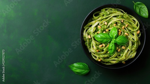Delicious green pasta garnished with fresh basil leaves on dark