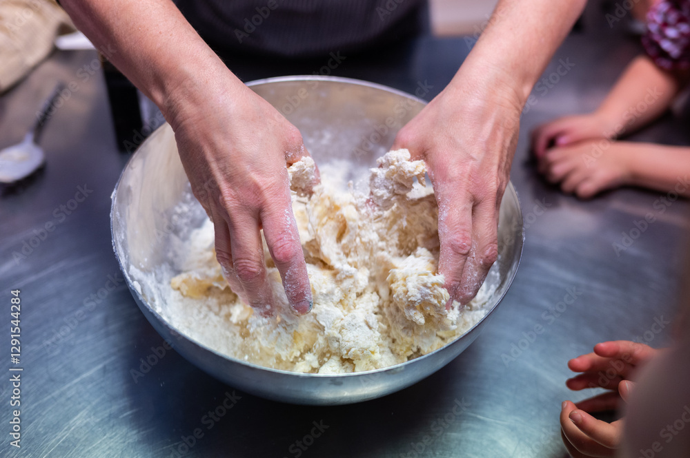 Hands of female chef kneading butter cookies dough during cooking class workshop for children Hands of female chef kneading butter cookies dough during cooking class workshop for children
