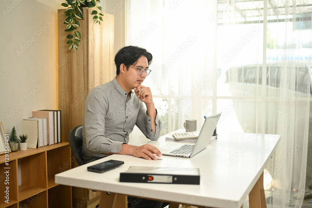 A businessman works on his laptop, analyzing data and making decisions on His workspace, Focused Business Planning concept A businessman works on his laptop, analyzing data and making decisions on His workspace, Focused Business Planning concept