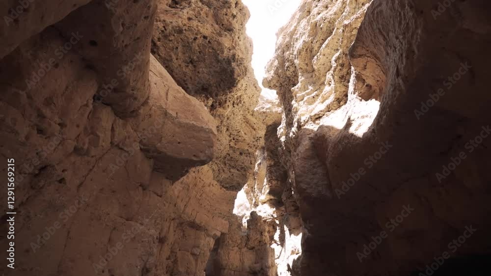 Sunlight illuminating rocky canyon passages unveiling textured geological formations