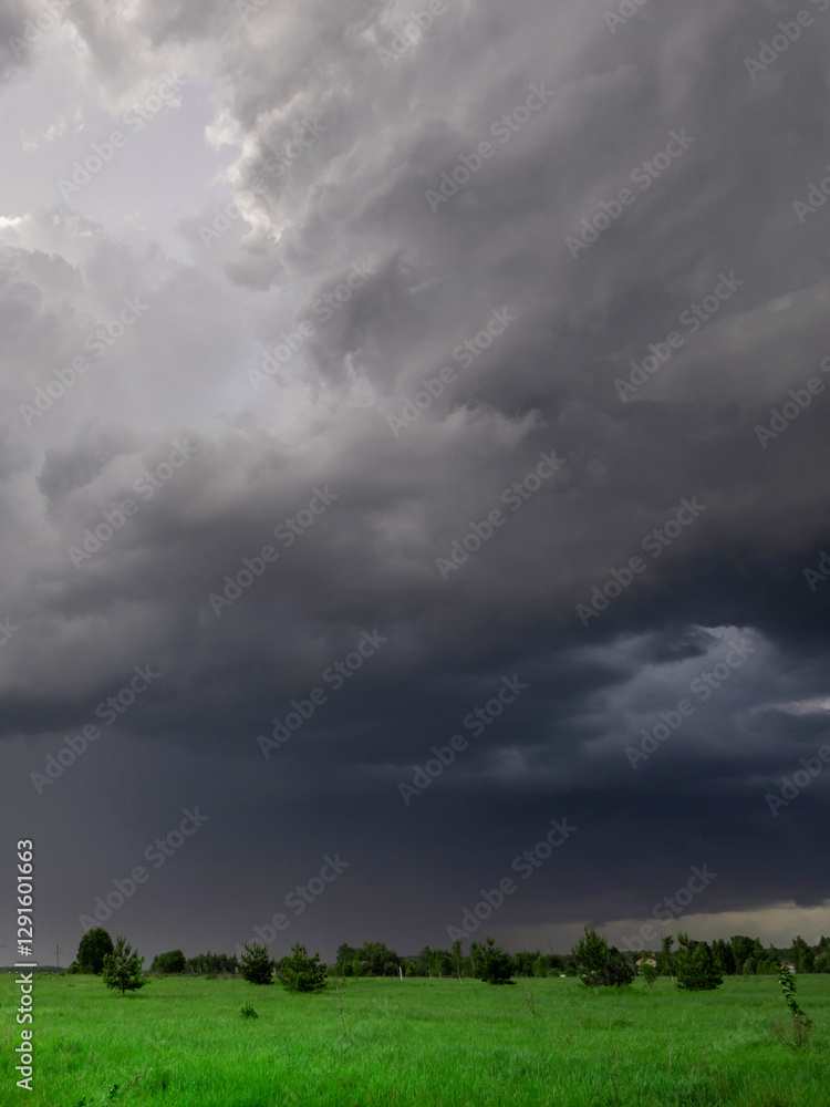 Stormy sky with dark clouds and a few trees in the background Stormy sky with dark clouds and a few trees in the background