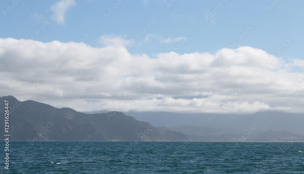 Delightful sea landscape with blue surface of the water, magic feather clouds on the sky over mountain in Kaikoura,New Zealand Delightful sea landscape with blue surface of the water, magic feather clouds on the sky over mountain in Kaikoura,New Zealand