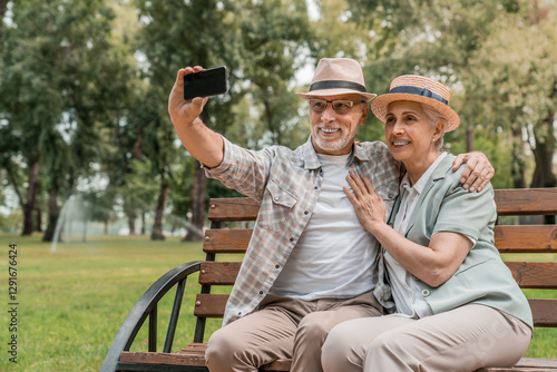 Wallpaper Mural Smile senior couple sitting a bench and selfie at park nature or countryside outdoor bonding together and love. Happy picture elderly man and woman taking photo for memory social media or retirement Torontodigital.ca