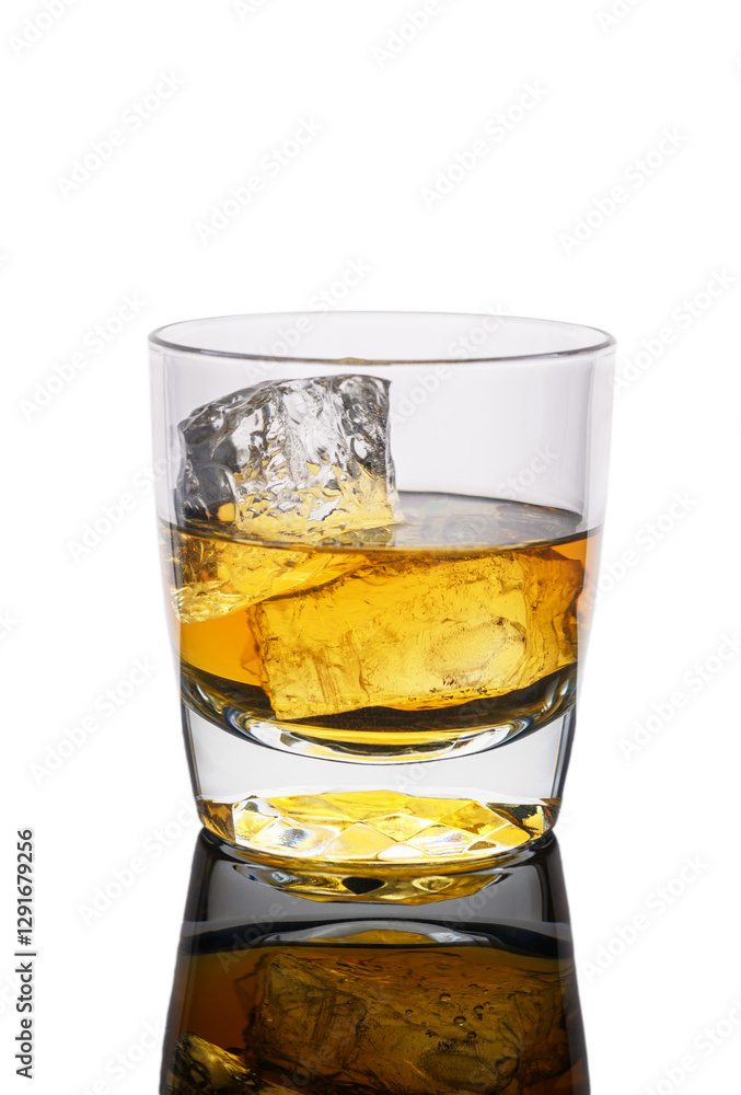 Golden drink in a clear glass with ice reflecting on a smooth surface Golden drink in a clear glass with ice reflecting on a smooth surface