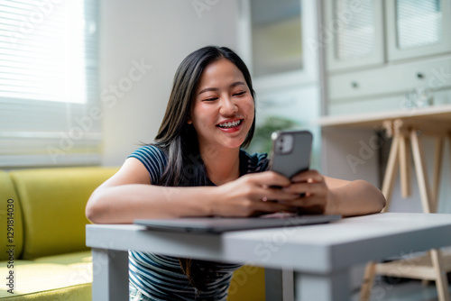 Young Asian Woman Using Smartphone and Laptop at Home Free Download Young Asian Woman Using Smartphone and Laptop at Home - GFXLoad