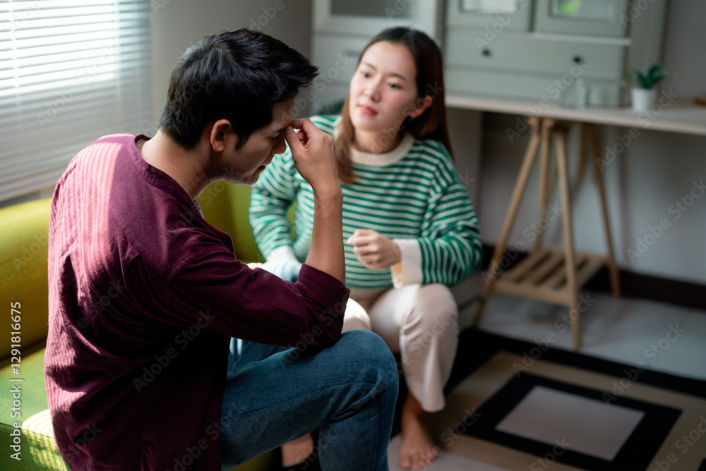 Stressed young man having headache and arguing with girlfriend at home Stressed young man having headache and arguing with girlfriend at home