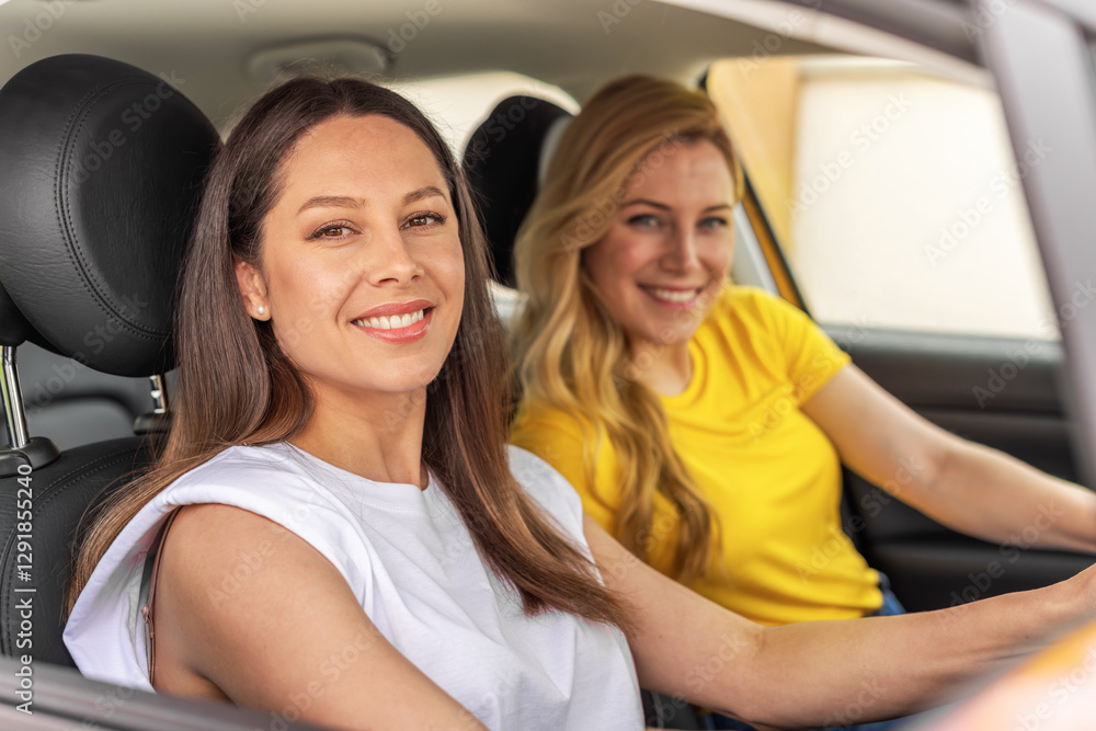 Two smiling women sit in a modern yellow car, radiating happiness and excitement as they embark on a journey together, symbolizing friendship and adventure.