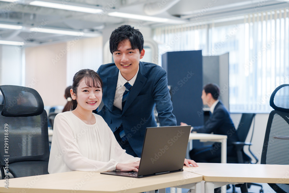 先輩社員から業務を教えてもらう新人の女性 先輩社員から業務を教えてもらう新人の女性