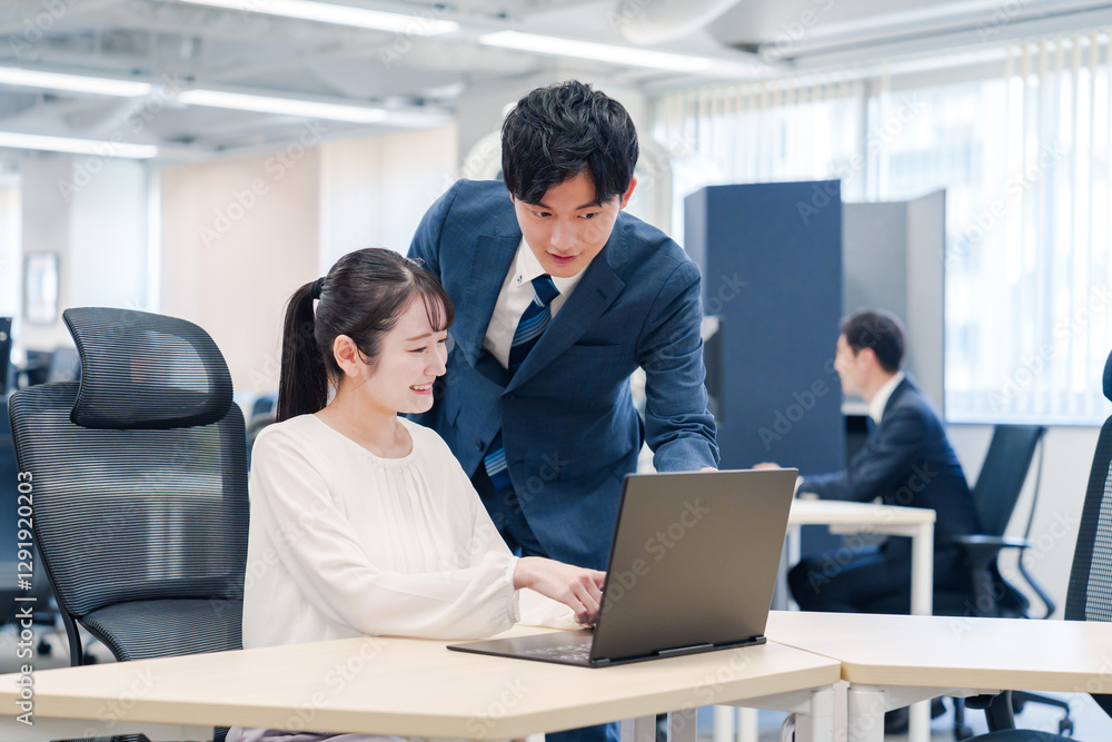 先輩社員から業務を教えてもらう新人の女性 先輩社員から業務を教えてもらう新人の女性