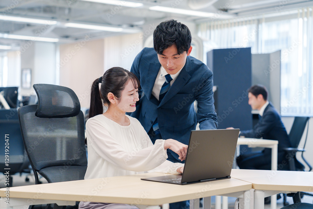 先輩社員から業務を教えてもらう新人の女性 先輩社員から業務を教えてもらう新人の女性