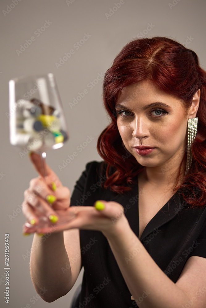 Captivating redhead woman holding glass in hand with colorful contents displaying elegance, allure, and art of balance, artistic expression concept