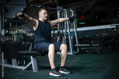 Wallpaper Mural Man Lifting Weights During Evening Workout in Gym Torontodigital.ca
