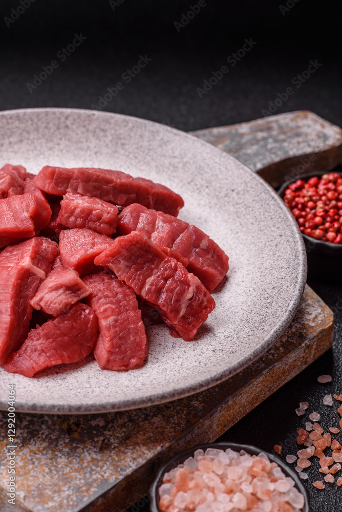 Raw beef tenderloin cut into slices with salt and spices Raw beef tenderloin cut into slices with salt and spices