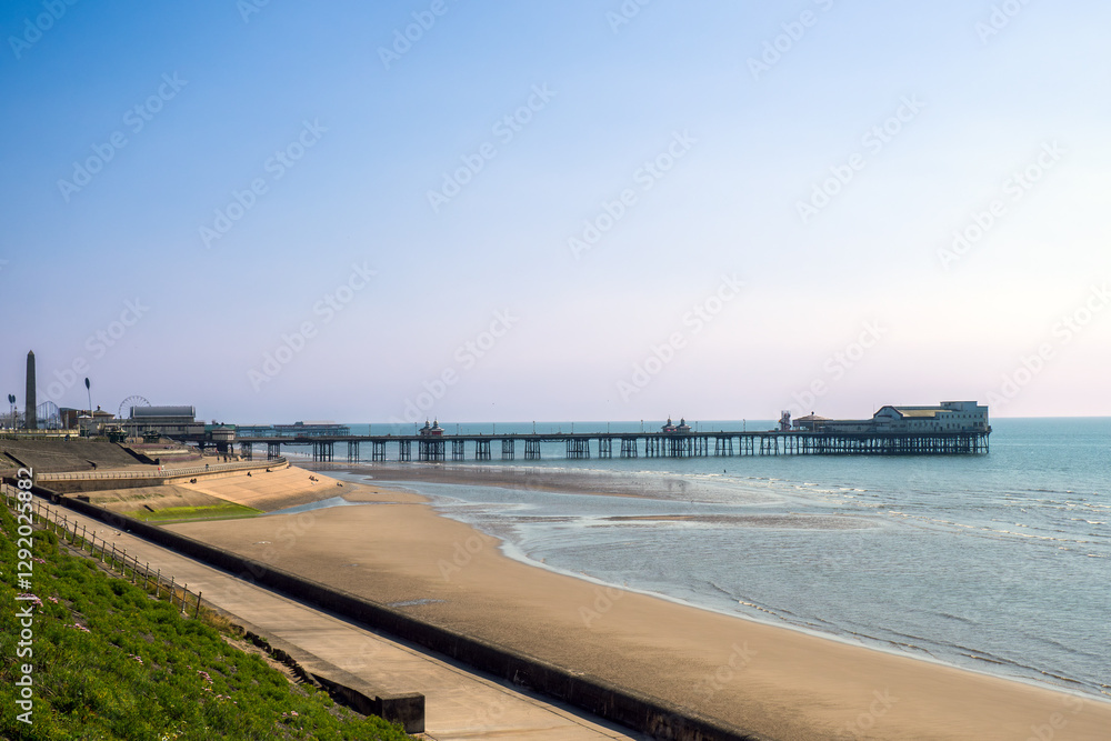 North Pier in Blackpool from the promenade with the beach and sea in afternoon summer sunlight North Pier in Blackpool from the promenade with the beach and sea in afternoon summer sunlight