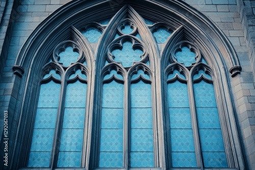 Ornate stone tracery surrounds a beautiful stained glass window in a gothic revival style building
