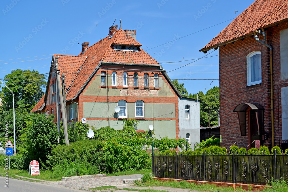KALININGRAD REGION, RUSSIA - JUNE 27, 2016: Residential building with a hip roof, pre-war building. Yantarny village KALININGRAD REGION, RUSSIA - JUNE 27, 2016: Residential building with a hip roof, pre-war building. Yantarny village