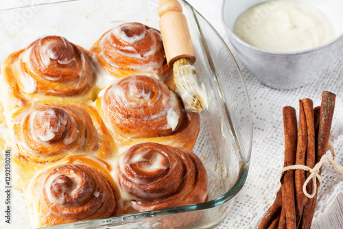 Obraz na płótnie Cinnabons, cinnamon rolls topped with a cream of cream, cheese and sugar. w salonie