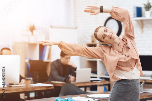 A girl is doing gymnastic exercises at work.