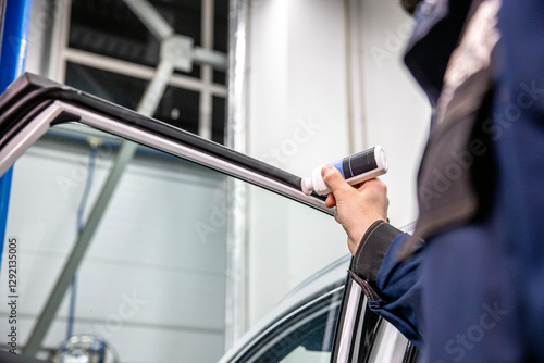 Silicone lubricant application on car window rubber seal, prevent cracking, ensure long-lasting waterproofing, regular vehicle detailing and maintenance. Hand applying sealant to car rubber door seal