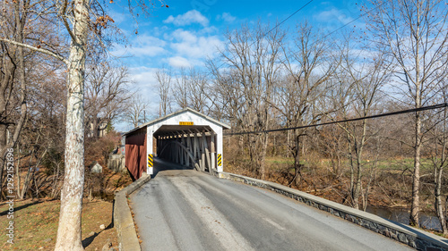 Photos A charming covered bridge spans a tranquil road in a rural setting