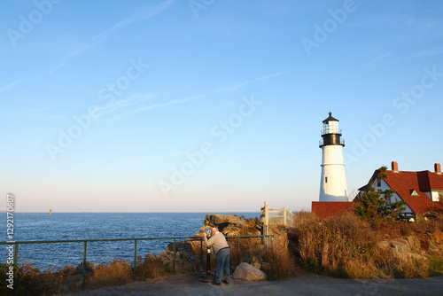 Fotografie Elderly widower man on vacation looking out at the sea or ocean through a coin o