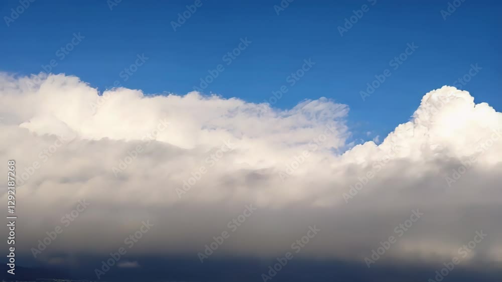 Fluffy white clouds drifting across a bright blue sky, creating a peaceful and serene atmosphere