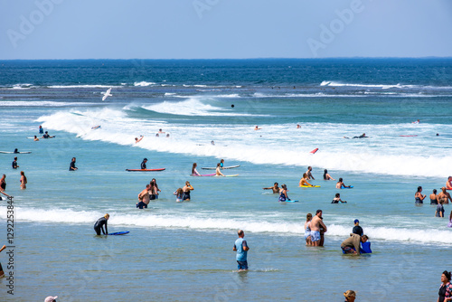 Photography People enjoying the ocean waters,swimmers and surfers in the turquoise water, wading, swimming, and riding waves at Torquay surf beach on the Great Ocean Road in Australia