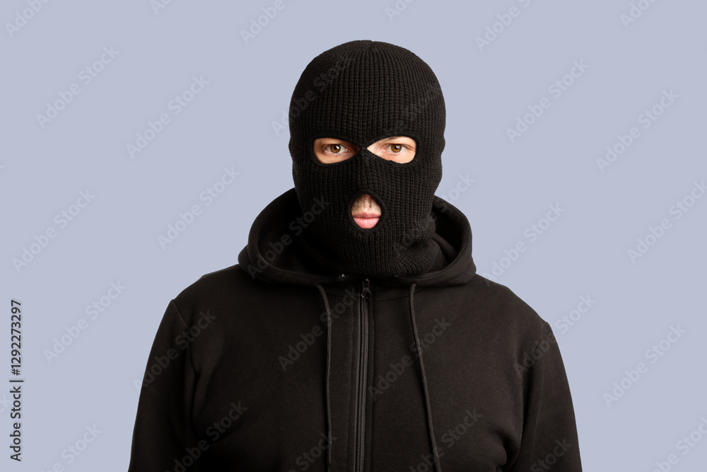 Riots, Robbery and Marauding Concept. Portrait of disguised villain in black mask posing at camera on white background Riots, Robbery and Marauding Concept. Portrait of disguised villain in black mask posing at camera on white background
