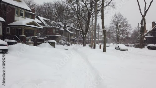 Wallpaper Mural Snowy winter in Toronto, Ontario, Canada. Walking along a narrow path among snowdrifts through a residential area with two-story buildings during a snowfall. Yards, wrought-iron fences. Torontodigital.ca