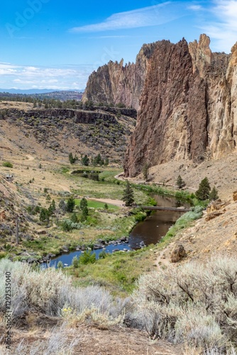 High angle view of river, a scenic landscape with a wooden bridge and surrounding rock formations. Hikers enjoy the natural beauty. Smith Rock State Park, Terrebonne, Oregon, United States photo