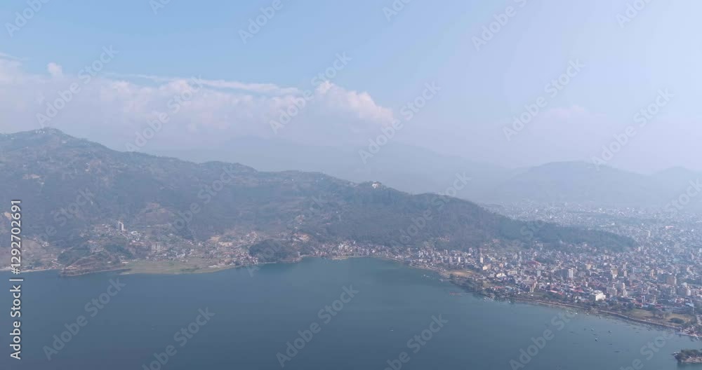 aerial view of the cityscape of Pokhara nestled beside Phewa Lake and surrounded by lush, rolling hills aerial view of the cityscape of Pokhara nestled beside Phewa Lake and surrounded by lush, rolling hills