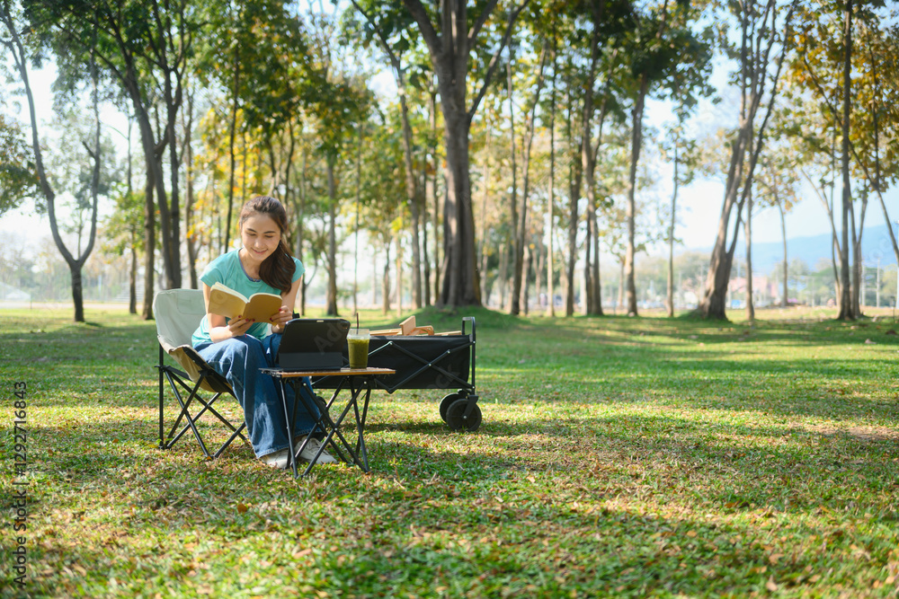 Cheerful woman sitting on foldable chair in a green park, reading a book Cheerful woman sitting on foldable chair in a green park, reading a book