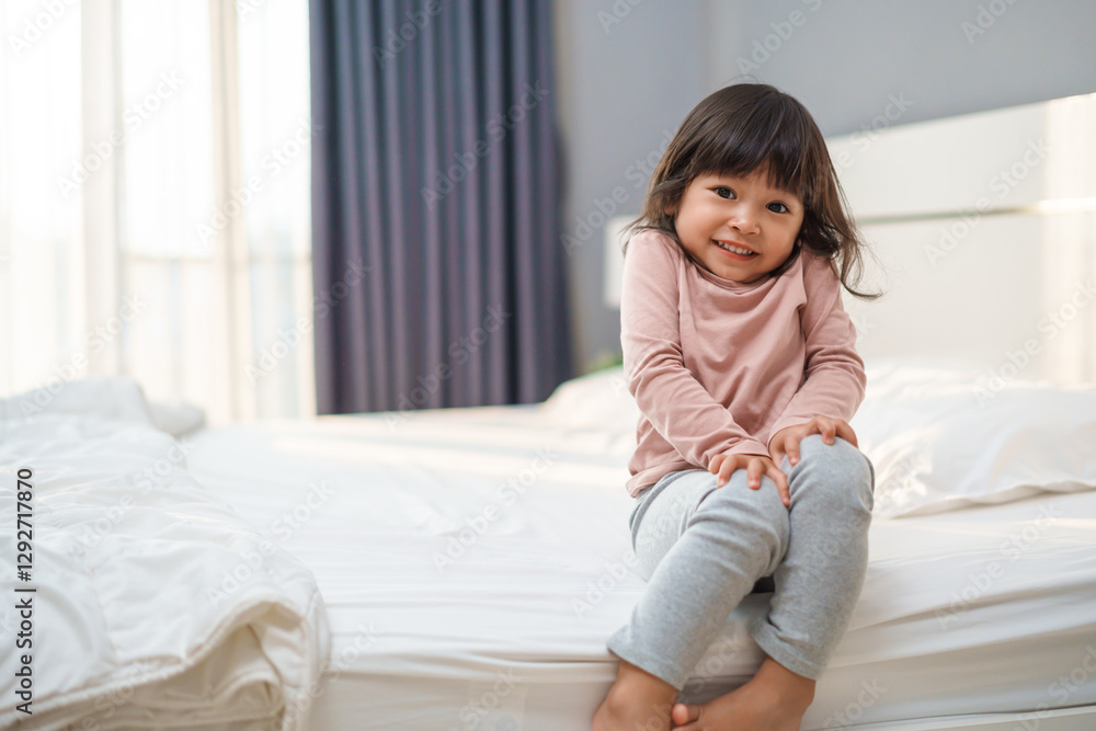 happy toddler girl smilling on bed