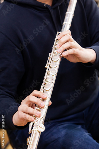 Hands of a musician playing a large flute