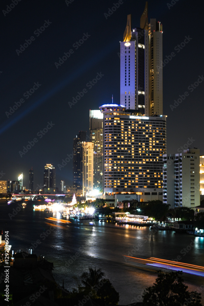 Obraz premium View of Bangkok, Thailand at night, showing the Chao Phraya River and boats. Taken on 22 Dec 2023.