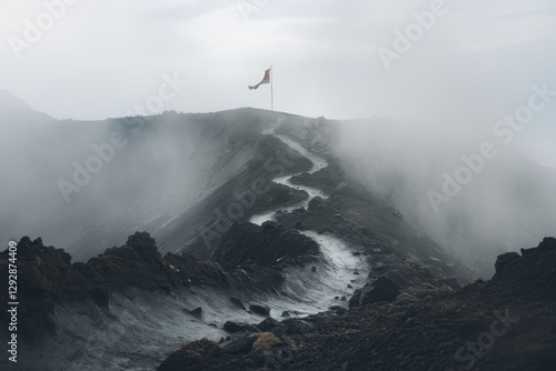 A switchback path scaling a mist-shrouded volcanic slope, revealing a triumphant banner at the crater’s edge, underscoring resilience and resolve