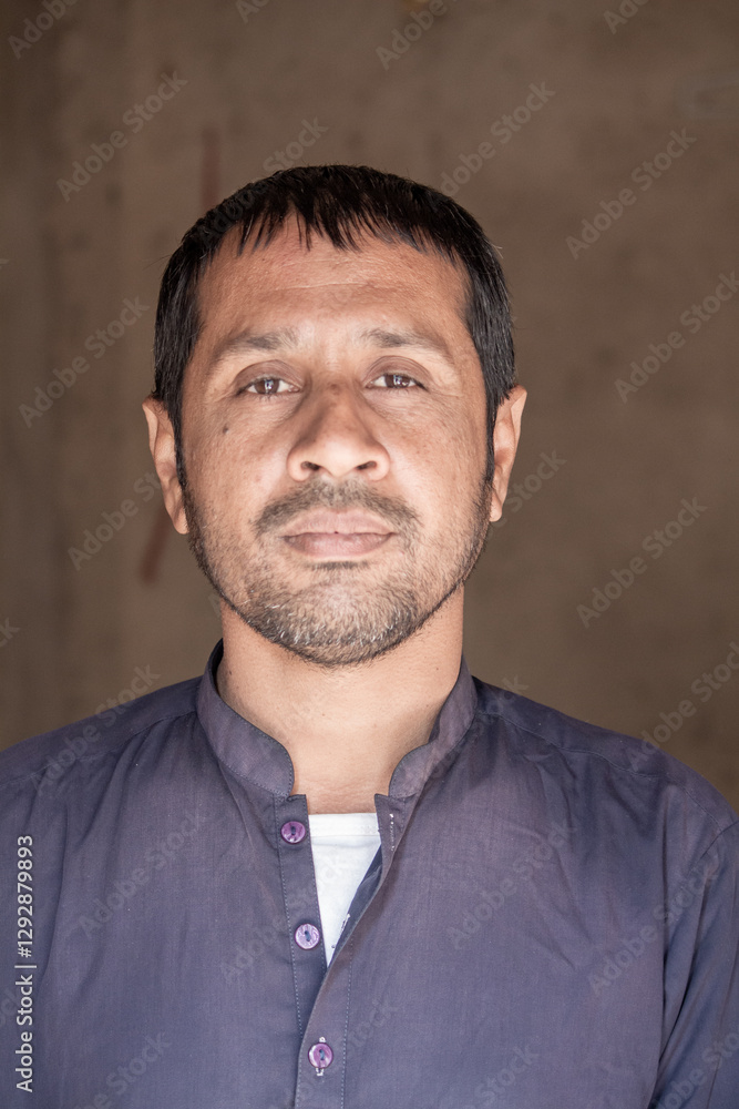Obraz premium Portrait of a Pakistani Man in Traditional Dress | Rural Background | Confident Expression | Natural Lighting