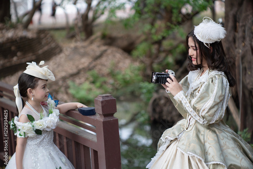 Obraz na płótnie Two sister wearing vintage clothes are having fun happily in a large garden house. w salonie