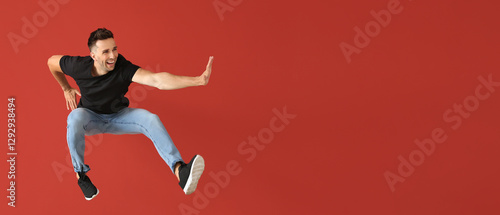 Handsome jumping young man against color background
