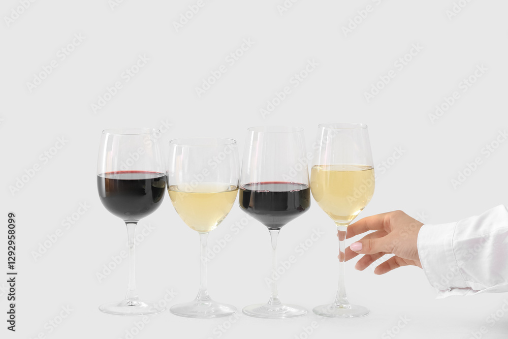 Female hand with glasses different exquisite wine on light background Female hand with glasses different exquisite wine on light background