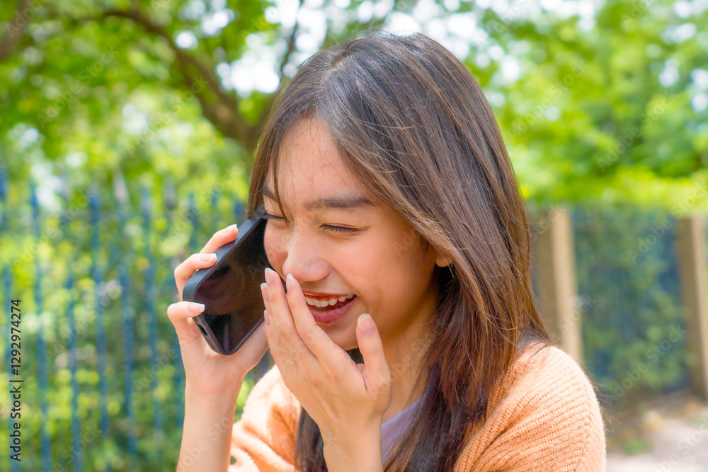 Asian young woman talking on cellphone smiling laughing while walking outdoors in city. Teenage girl use smartphone communicate online while traveling outside in downtown. Asian young woman talking on cellphone smiling laughing while walking outdoors in city. Teenage girl use smartphone communicate online while traveling outside in downtown.